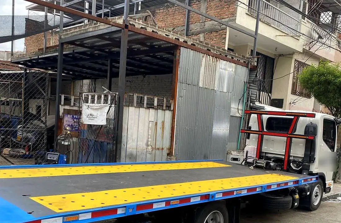 Grúa con planchón azul y amarillo de Ing. Metálicas Sánchez SAS